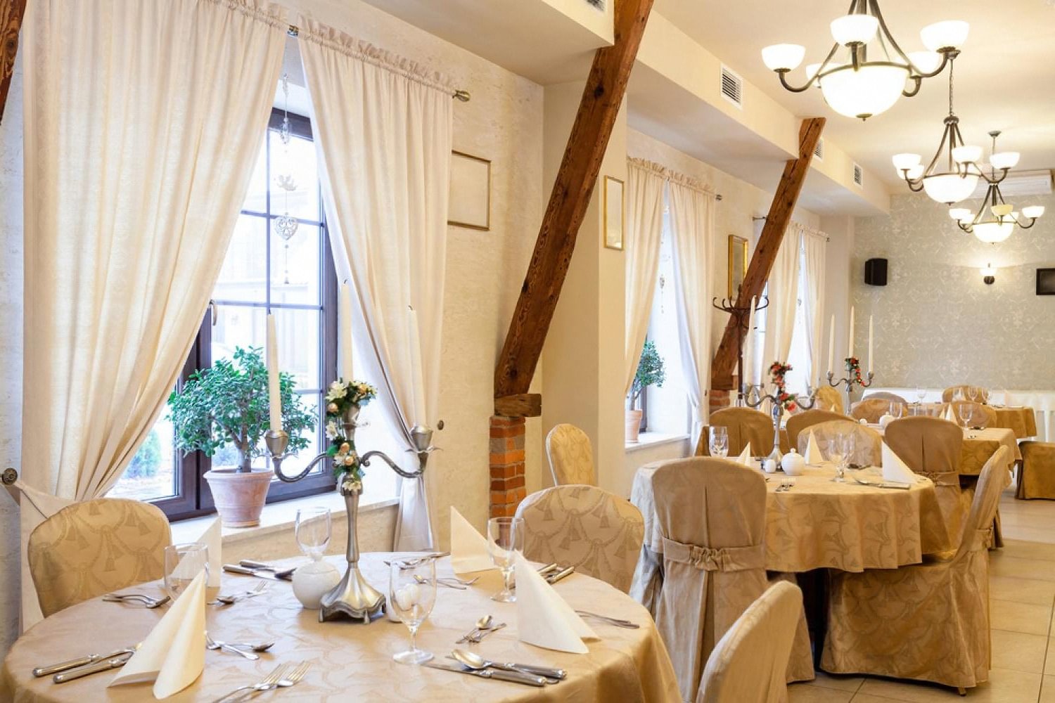 Elegant banquet hall in Dubai with rented chair covers, round tables and candelabra centrepieces set for a wedding reception