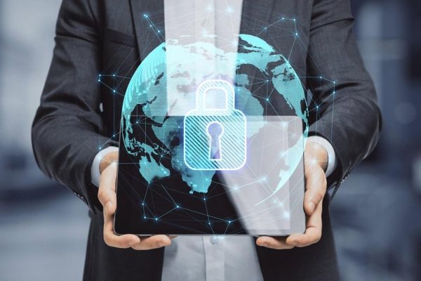 Businessman holding a tablet showing a global network and padlock symbolising compliance and risk management