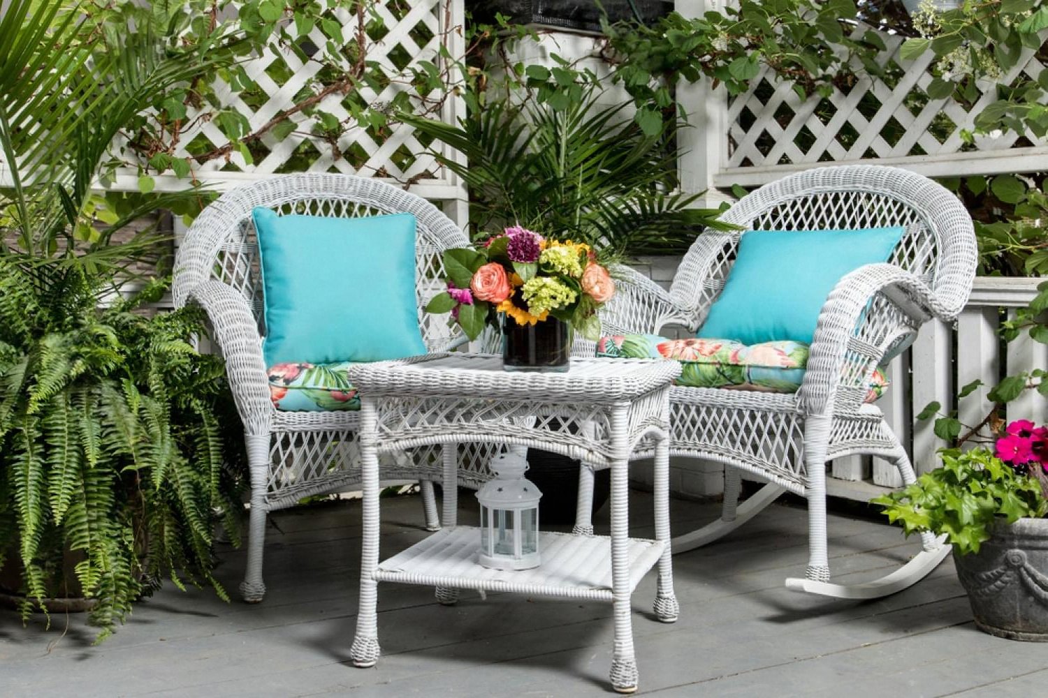 White wicker outdoor lounge furniture with turquoise cushions and side table, styled for a garden event in Dubai